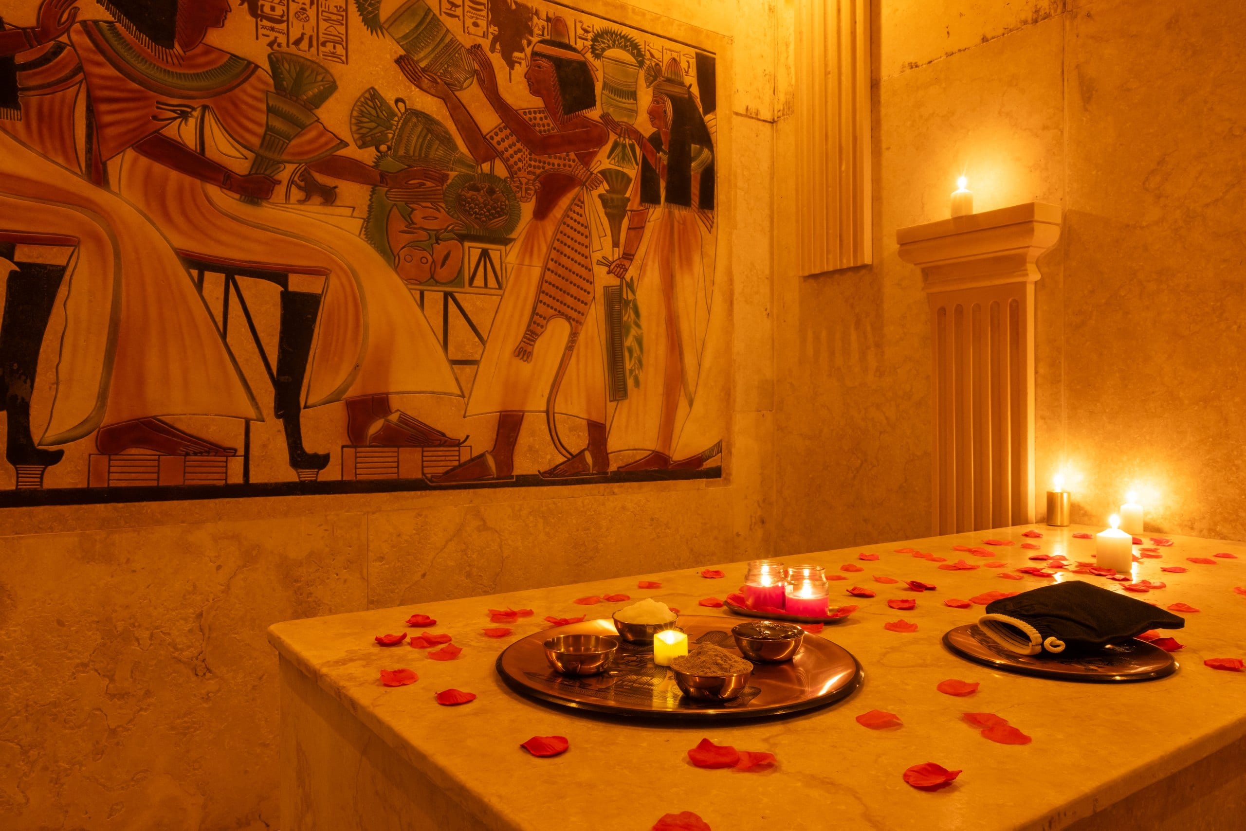 Mesa del hammam con pétalos, cuencos y velas